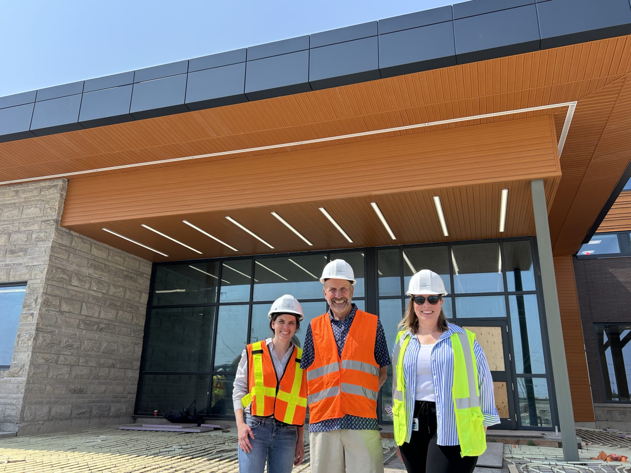 Stewart Richardson poses with NCAM staff in front of new facility construction