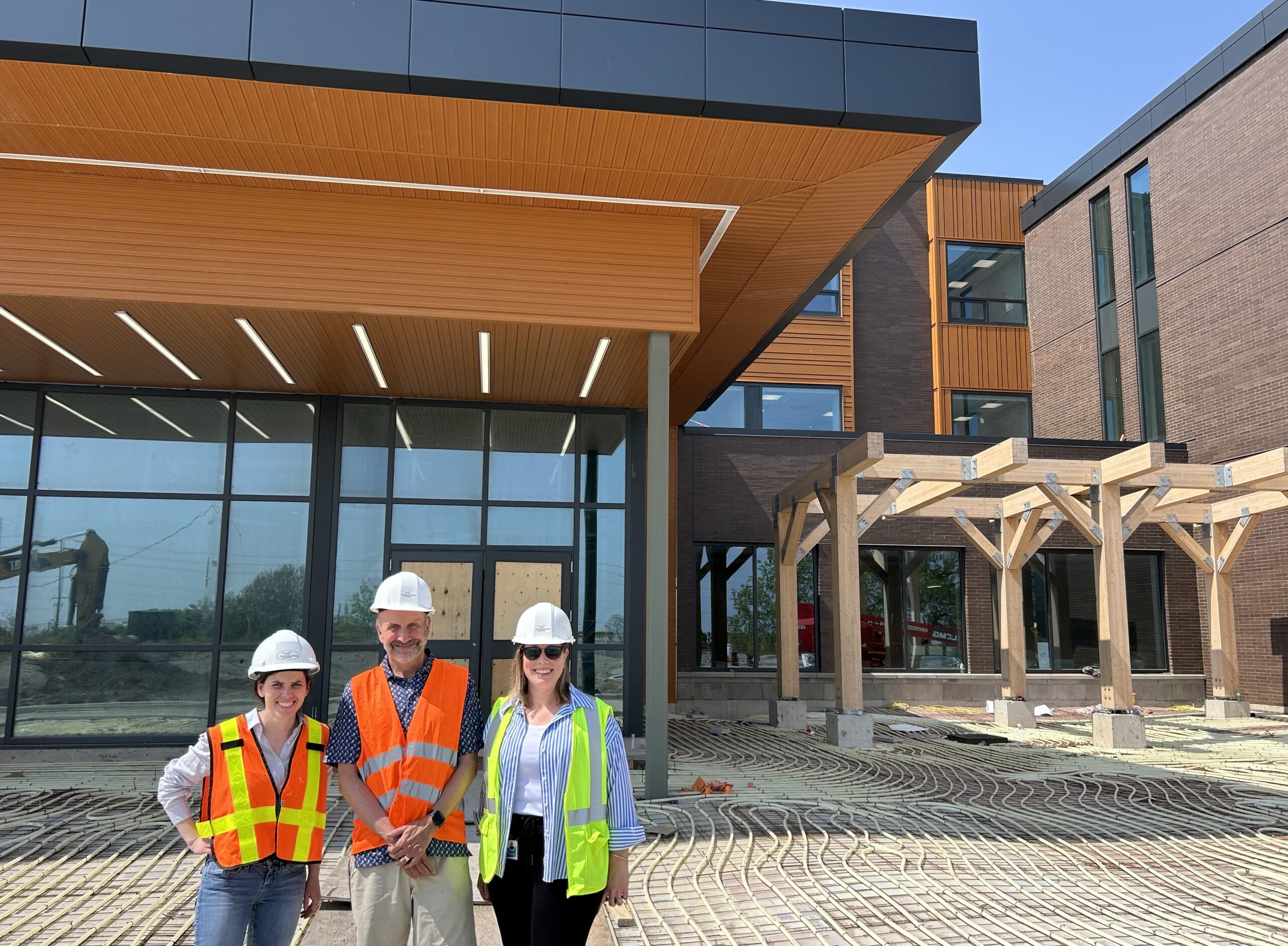 Stewart Richardson poses with NCAM staff in front of new facility construction