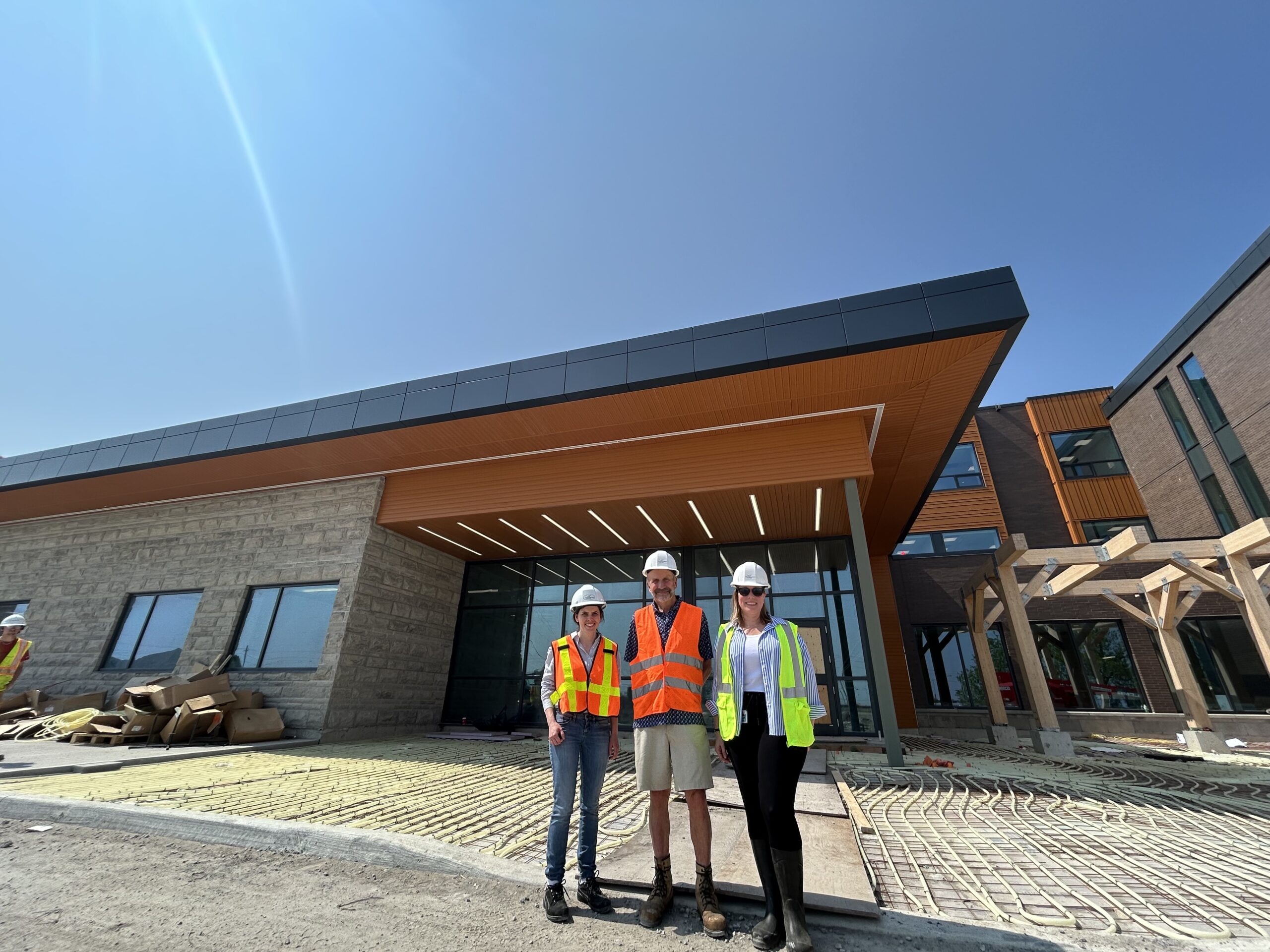 Stewart Richardson poses with NCAM staff in front of new facility construction